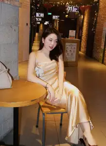 Elegant Young Woman in Golden Silk Dress Shines in Modern Urban Setting. Captivating Style. Code: 1000026984-2