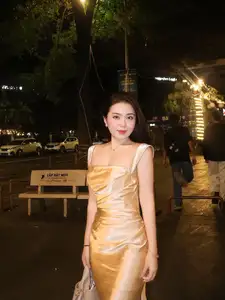 Elegant Young Woman in Golden Silk Dress Shines in Modern Urban Setting. Captivating Style. Code: 1000026984-1