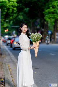 Elegant White Ao Dai: Graceful Vietnamese Girl's Beauty with a Pristine Floral Bouquet-12