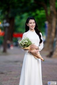 Elegant White Ao Dai: Graceful Vietnamese Girl's Beauty with a Pristine Floral Bouquet-0