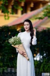 Elegant White Ao Dai: Graceful Vietnamese Girl's Beauty with a Pristine Floral Bouquet-3