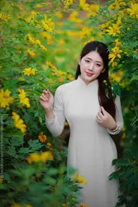 Radiant Youth: Vietnamese Girl in Elegant White Ao Dai Amidst Golden Blooms-1