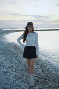 Dreamy Sunset by the Sea: Young Woman Relaxing and Gazing-1