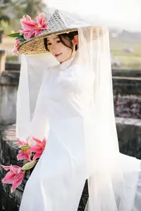 Discover the captivating grace of a Vietnamese woman in a flowing white Ao Dai and traditional conical hat-5