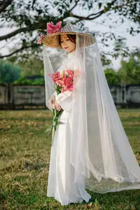 Discover the captivating grace of a Vietnamese woman in a flowing white Ao Dai and traditional conical hat-20
