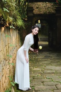 Elegant Vietnamese Woman in Traditional White Ao Dai, Gracing an Ancient Pathway | 1000017528-5