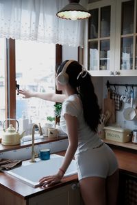 Young Woman Relaxing with Headphones & Music in Cozy Kitchen: Serene Home Lifestyle Moment-14