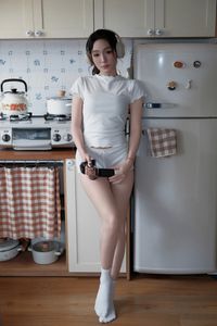 Young Woman Relaxing with Headphones & Music in Cozy Kitchen: Serene Home Lifestyle Moment-11