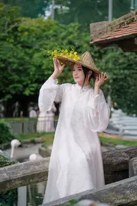 Vietnamese Beauty: Elegant Girl in White Ao Dai, Conical Hat with Yellow Flowers in Ancient Garden-0