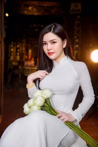 VGU No.69: Graceful Vietnamese beauty in pristine white Ao Dai with pure lotus, exuding captivating Asian charm.-4
