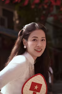 VGU No.110: Elegant White Ao Dai Amidst Red Flags, Celebrating Vietnamese Grace and Patriotism.-4