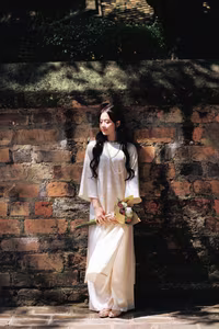 VGU No.131: Graceful young woman in traditional dress, timeless Vietnamese beauty against ancient brick.-11