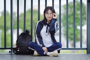 Radiant Youth: Girl in Uniform Playfully Blowing Bubbles in Lush Greenery 1000019736-2