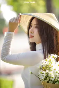 Captivating Beauty: Vietnamese Girl in White Ao Dai with Delicate Daisies.-7