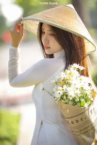 Captivating Beauty: Vietnamese Girl in White Ao Dai with Delicate Daisies.-8