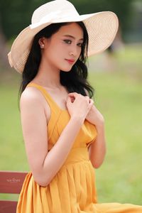 Charming Girl in Yellow Dress with Wide-Brim Hat Outdoors-0