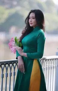 Vietnamese Grace: Elegant Woman in Green Ao Dai with Pink Lotus Flower 1000025232-0