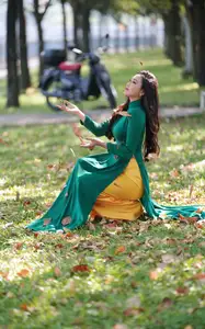 Vietnamese Grace: Elegant Woman in Green Ao Dai with Pink Lotus Flower 1000025232-9