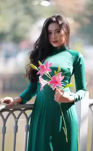 Vietnamese Grace: Elegant Woman in Green Ao Dai with Pink Lotus Flower 1000025232-12