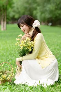 Pure Young Woman with Vibrant Yellow Flowers: Natural Beauty in a Lush Green Setting 1000019709-11