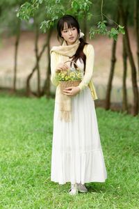 Pure Young Woman with Vibrant Yellow Flowers: Natural Beauty in a Lush Green Setting 1000019709-9