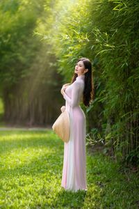 Elegant Vietnamese Woman in Pink Ao Dai Gracing a Sunny Park-9