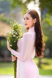 Elegant Vietnamese Woman in Pink Ao Dai Gracing a Sunny Park-0