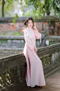 Elegant Vietnamese Beauty: Young Woman Gracefully Posing in Pink Ao Dai with White Orchids 1000026874-10