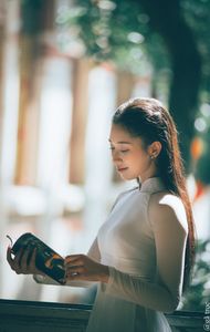 Graceful Vietnamese Girl in White Ao Dai by Window, Celebrating Traditional Beauty-4