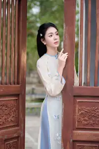 Graceful Ao Dai: The Ethereal Beauty of a Vietnamese Woman with White Orchids, Inspiring Tradition.-4