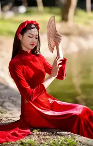 Discover the enchanting beauty of a Vietnamese woman in a traditional Red Ao Dai by the tranquil water.-5