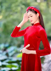 Discover the enchanting beauty of a Vietnamese woman in a traditional Red Ao Dai by the tranquil water.-4