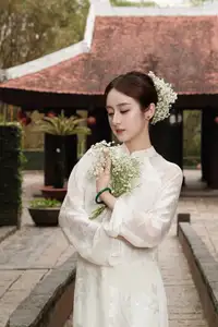 Gentle Elegance: Vietnamese Girl in Pure White Ao Dai with Hair Flowers - Traditional Beauty.-2