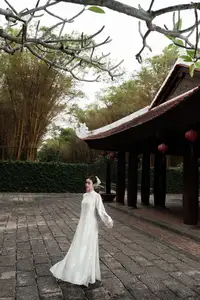 Gentle Elegance: Vietnamese Girl in Pure White Ao Dai with Hair Flowers - Traditional Beauty.-5